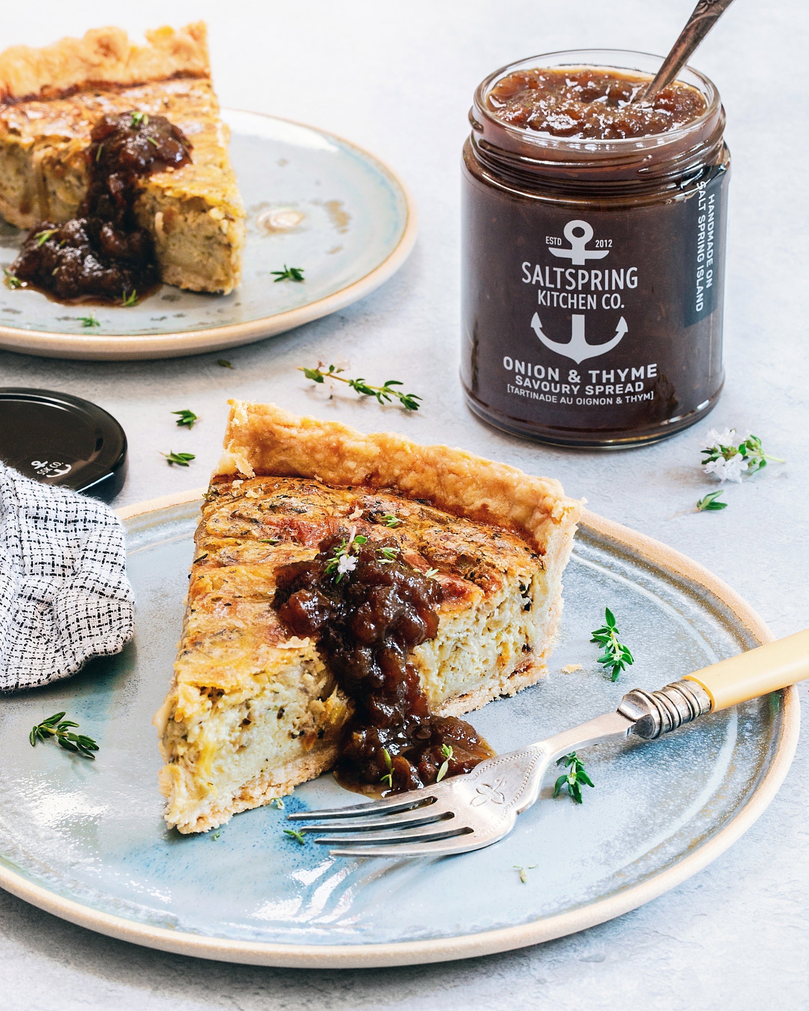 Salt Spring Kitchen Company - Onion Thyme Quiche on a plate with a jar of Onion Thyme Savoury Spread