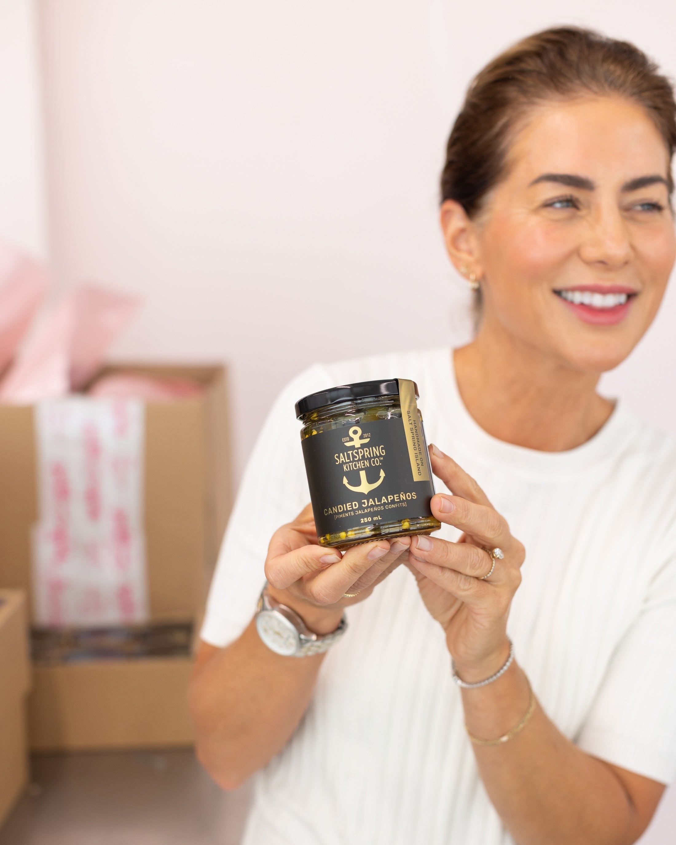 Jillian Harris holding a jar of SaltSpring Kitchen Company Candied Jalapeños